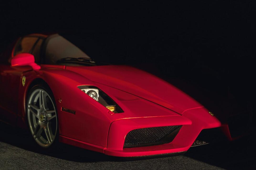 Vintage red Ferrari parked inside an elegant auction hall